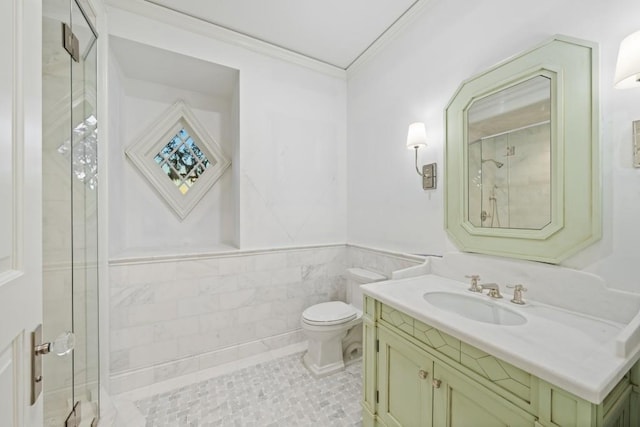 bathroom featuring walk in shower, crown molding, toilet, vanity, and tile walls