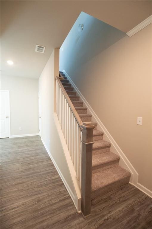 stairway with hardwood / wood-style flooring and crown molding