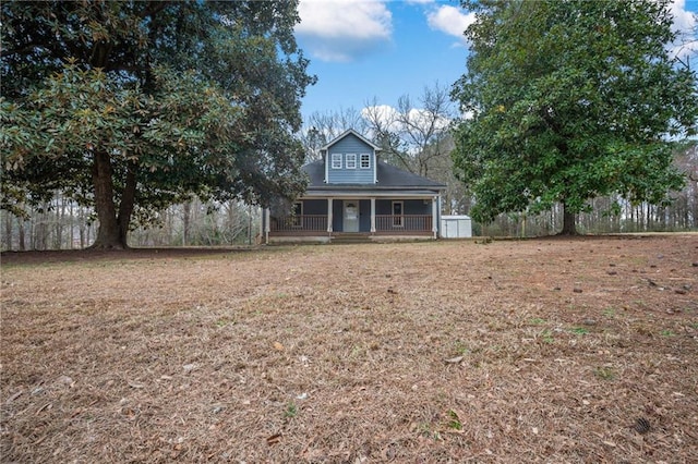 view of front of house featuring a porch, fence, and a front lawn