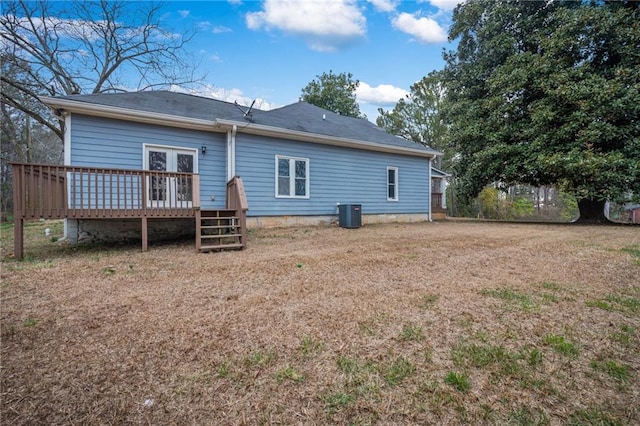 rear view of property with a lawn, a wooden deck, and central air condition unit