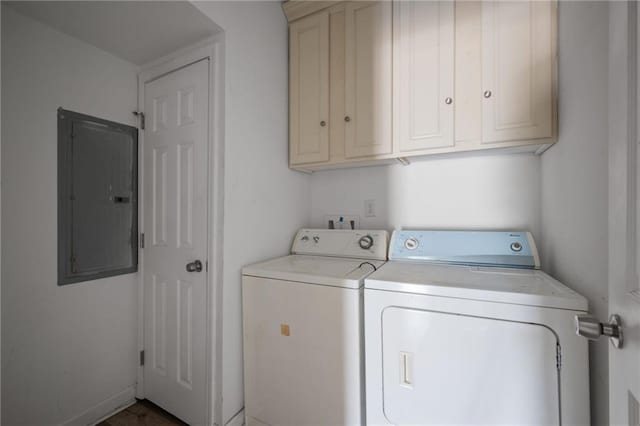 washroom featuring cabinet space, washing machine and dryer, and electric panel