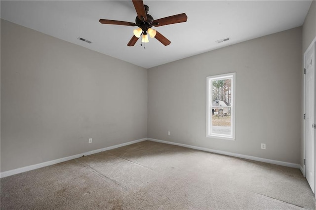 empty room featuring carpet floors, visible vents, and baseboards