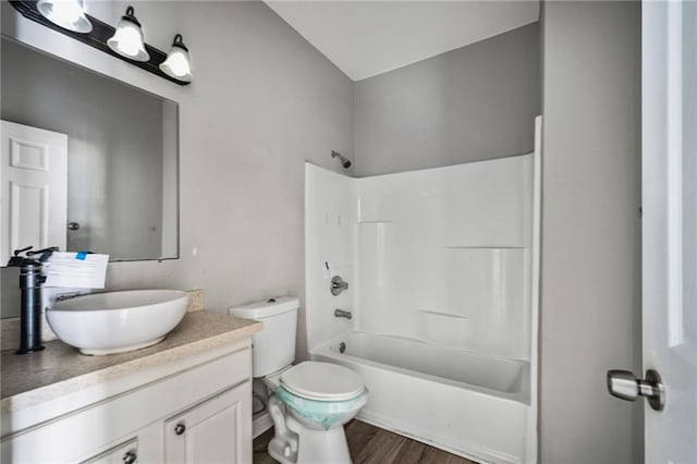 full bathroom featuring toilet, shower / washtub combination, wood finished floors, and vanity