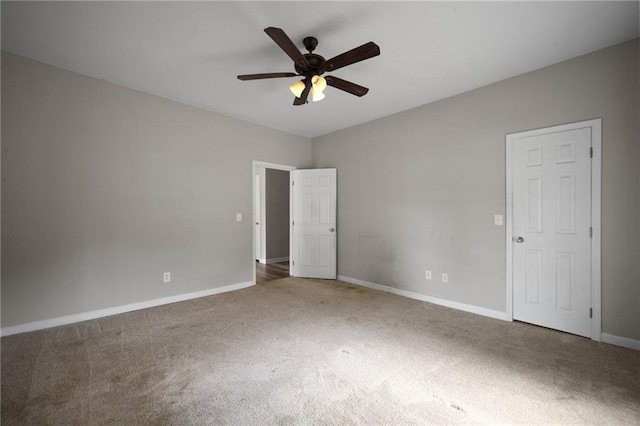 empty room with ceiling fan, carpet, and baseboards