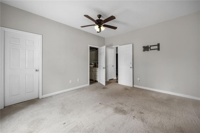 unfurnished bedroom featuring ceiling fan, carpet flooring, connected bathroom, and baseboards