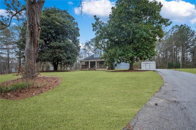 view of front of home with a garage, a front lawn, a porch, and aphalt driveway