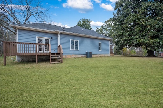 rear view of property featuring a lawn, a wooden deck, and central air condition unit