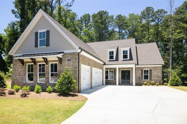 view of front of home with a garage, covered porch, and a front yard