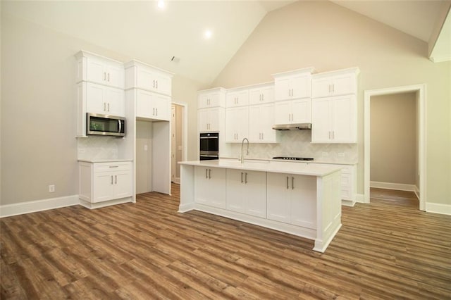 kitchen featuring a kitchen island with sink, white cabinetry, high vaulted ceiling, and stainless steel appliances