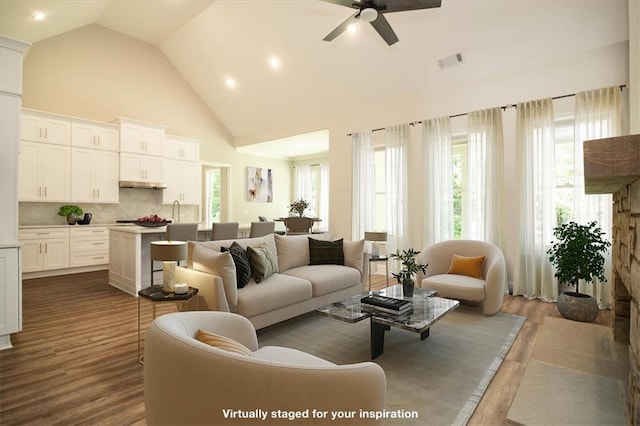 living room featuring ceiling fan, wood-type flooring, sink, and high vaulted ceiling