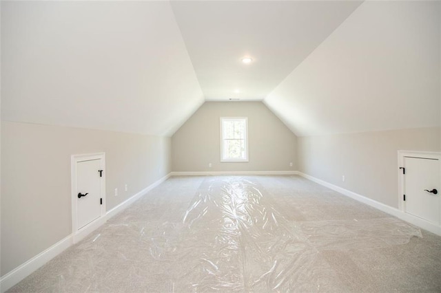 additional living space with light colored carpet and lofted ceiling