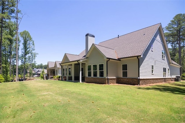 back of property with a yard and central AC