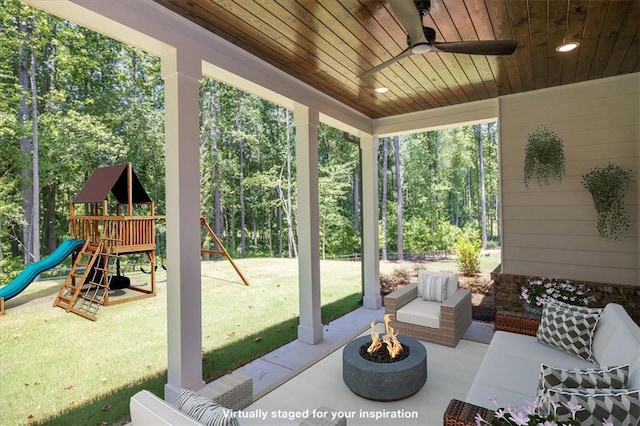 view of patio / terrace featuring ceiling fan, a playground, and an outdoor living space with a fire pit