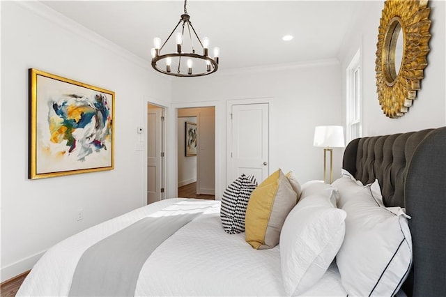 bedroom featuring ornamental molding, wood-type flooring, and an inviting chandelier