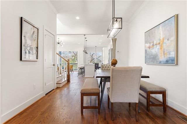 dining space featuring wood-type flooring and ornamental molding