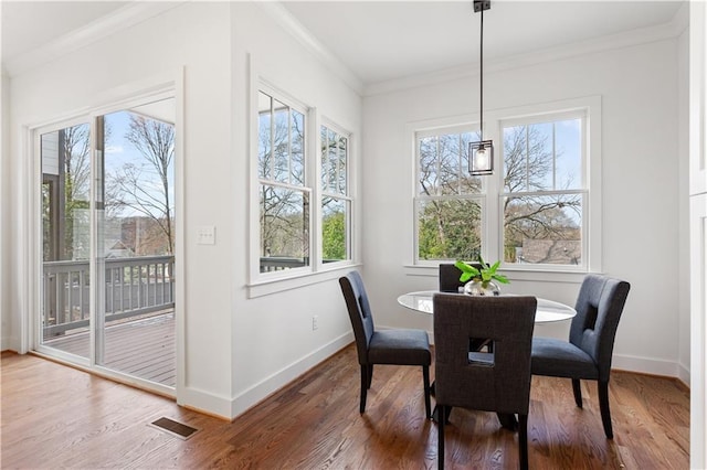 dining room featuring hardwood / wood-style flooring and crown molding