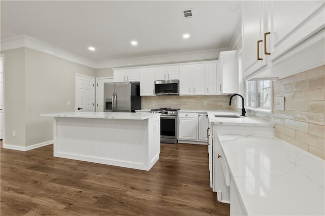 kitchen featuring white cabinetry, sink, dark hardwood / wood-style flooring, a kitchen island, and appliances with stainless steel finishes