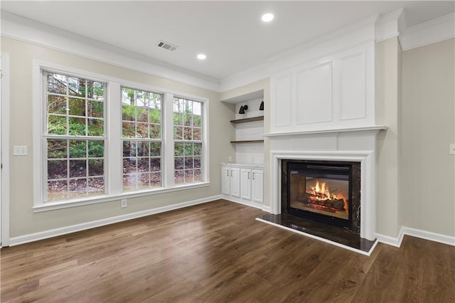 unfurnished living room featuring dark hardwood / wood-style floors, ornamental molding, and a wealth of natural light