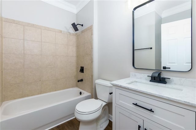 full bathroom featuring vanity, tiled shower / bath, hardwood / wood-style flooring, toilet, and ornamental molding