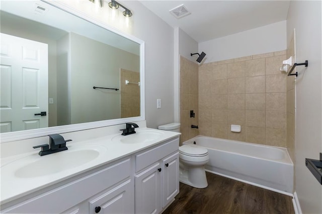 full bathroom featuring hardwood / wood-style floors, vanity, toilet, and tiled shower / bath