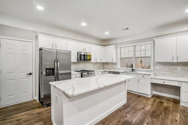 kitchen featuring sink, dark hardwood / wood-style flooring, a kitchen island, light stone counters, and stainless steel appliances