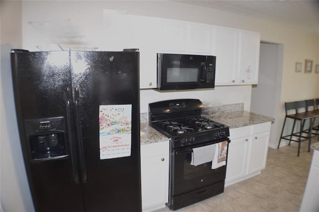 1371 Blazing Star Rd, Lawrenceville, GA 30045 - kitchen with black appliances, white cabinetry, and light stone countertops