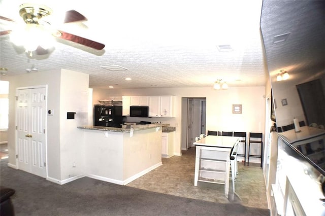 1371 Blazing Star Rd, Lawrenceville, GA 30045 - kitchen featuring black appliances, a peninsula, a kitchen breakfast bar, white cabinetry, and ceiling fan