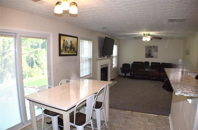 1371 Blazing Star Rd, Lawrenceville, GA 30045 - carpeted dining space with ceiling fan, a fireplace, and a textured ceiling