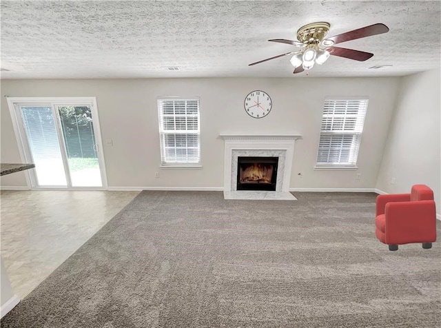 1371 Blazing Star Rd, Lawrenceville, GA 30045 - unfurnished living room featuring plenty of natural light, a premium fireplace, a ceiling fan, carpet flooring, and a textured ceiling
