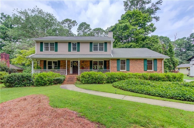2291 Smokehouse Path, Lawrenceville, GA 30044 - view of front of house featuring a chimney, a front lawn, and covered porch
