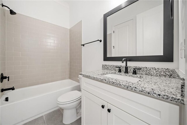 full bathroom featuring toilet, tile patterned flooring, vanity, and tiled shower / bath