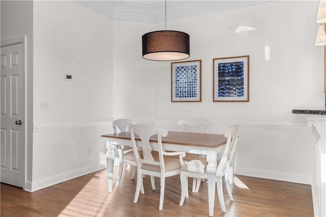 dining area with hardwood / wood-style floors and crown molding