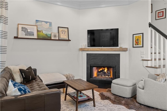 living room with crown molding and a tile fireplace