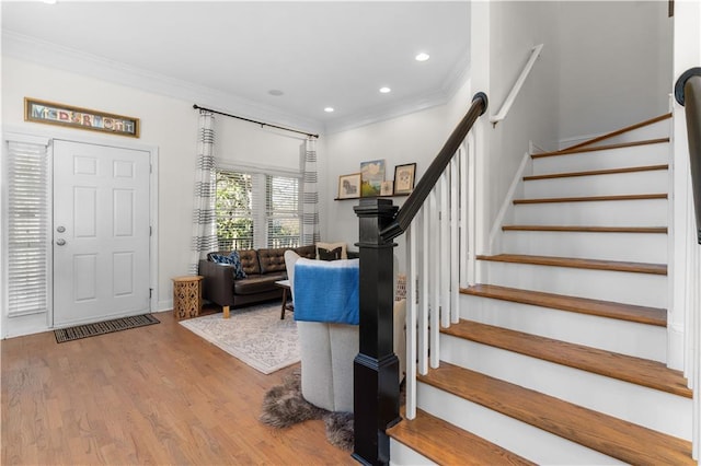 foyer entrance with hardwood / wood-style flooring and crown molding