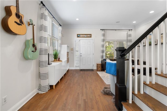 foyer with crown molding and hardwood / wood-style floors