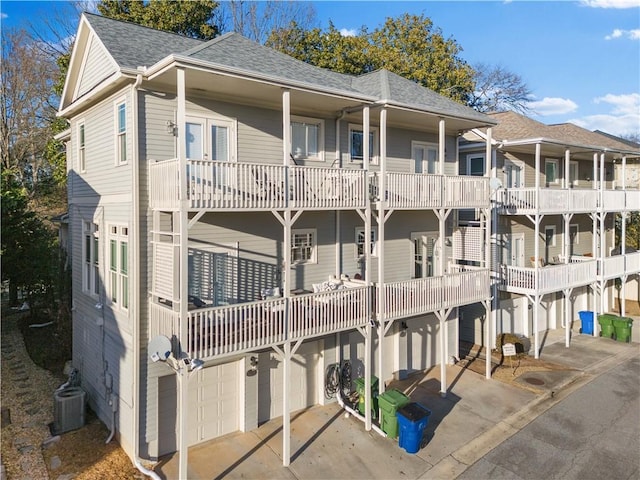 view of building exterior with a garage and central AC