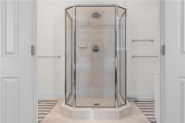 bathroom with an enclosed shower and tile patterned floors