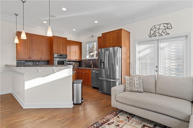 kitchen featuring a breakfast bar, stainless steel appliances, tasteful backsplash, decorative light fixtures, and kitchen peninsula