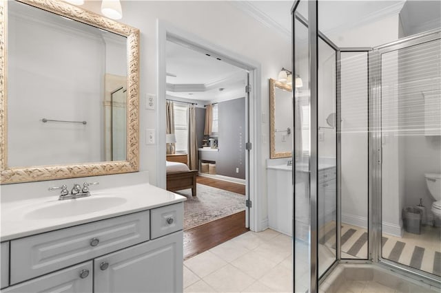 bathroom featuring tile patterned flooring, ornamental molding, an enclosed shower, and vanity