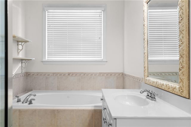 bathroom featuring vanity and tiled bath