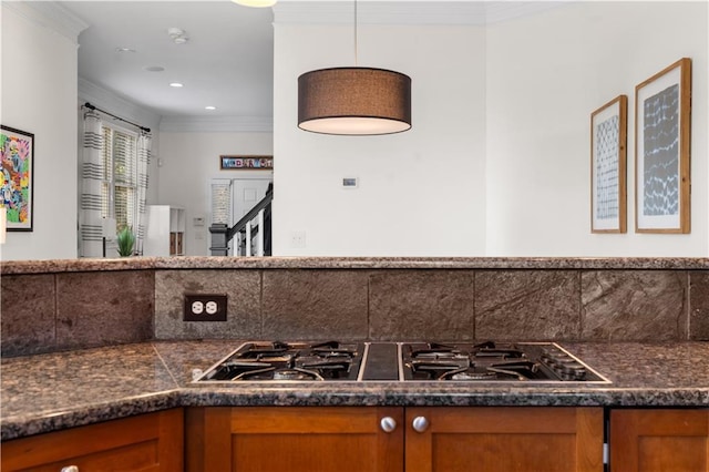 kitchen with crown molding, hanging light fixtures, stainless steel gas cooktop, and decorative backsplash