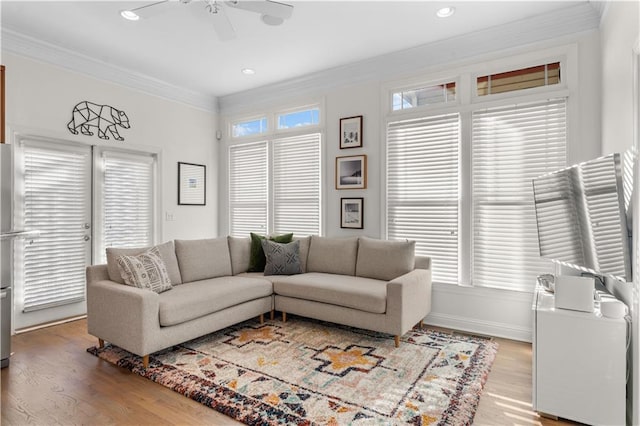 living room featuring hardwood / wood-style flooring, ornamental molding, plenty of natural light, and ceiling fan