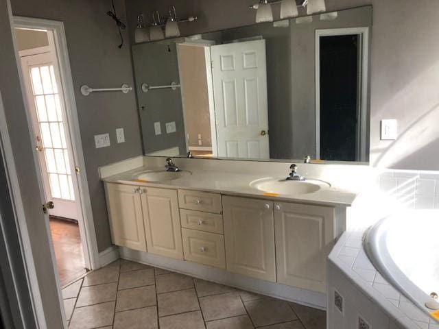 bathroom with tile patterned floors, a bathtub, and vanity