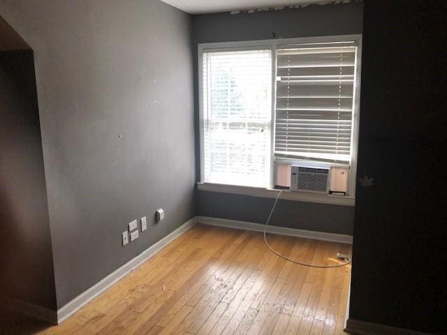 spare room featuring cooling unit and light wood-type flooring