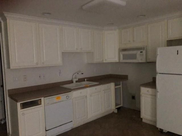 kitchen with sink, white cabinets, and white appliances