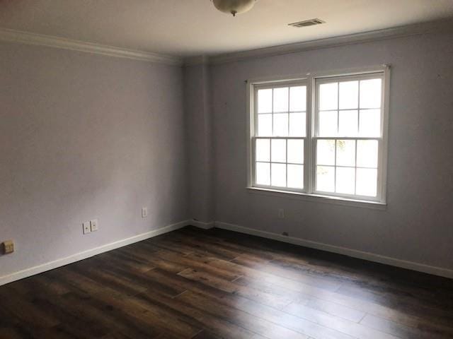 spare room with crown molding and dark wood-type flooring