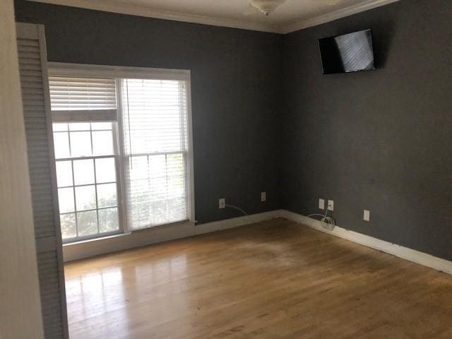 empty room with crown molding and hardwood / wood-style floors