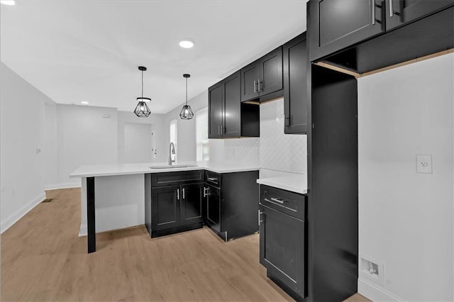1222 E Forrest Ave, Atlanta, GA 30344 - kitchen with a sink, light wood-style flooring, a peninsula, backsplash, and recessed lighting