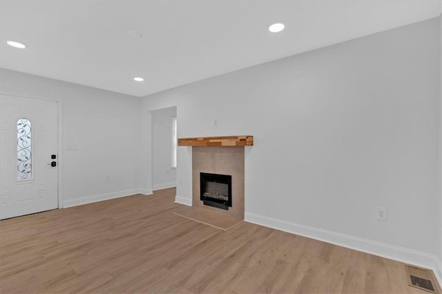 1222 E Forrest Ave, Atlanta, GA 30344 - unfurnished living room featuring a tile fireplace, light wood-style flooring, baseboards, and recessed lighting