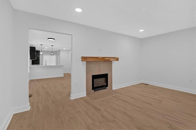 1222 E Forrest Ave, Atlanta, GA 30344 - unfurnished living room featuring light wood-style floors, a fireplace with flush hearth, baseboards, and recessed lighting